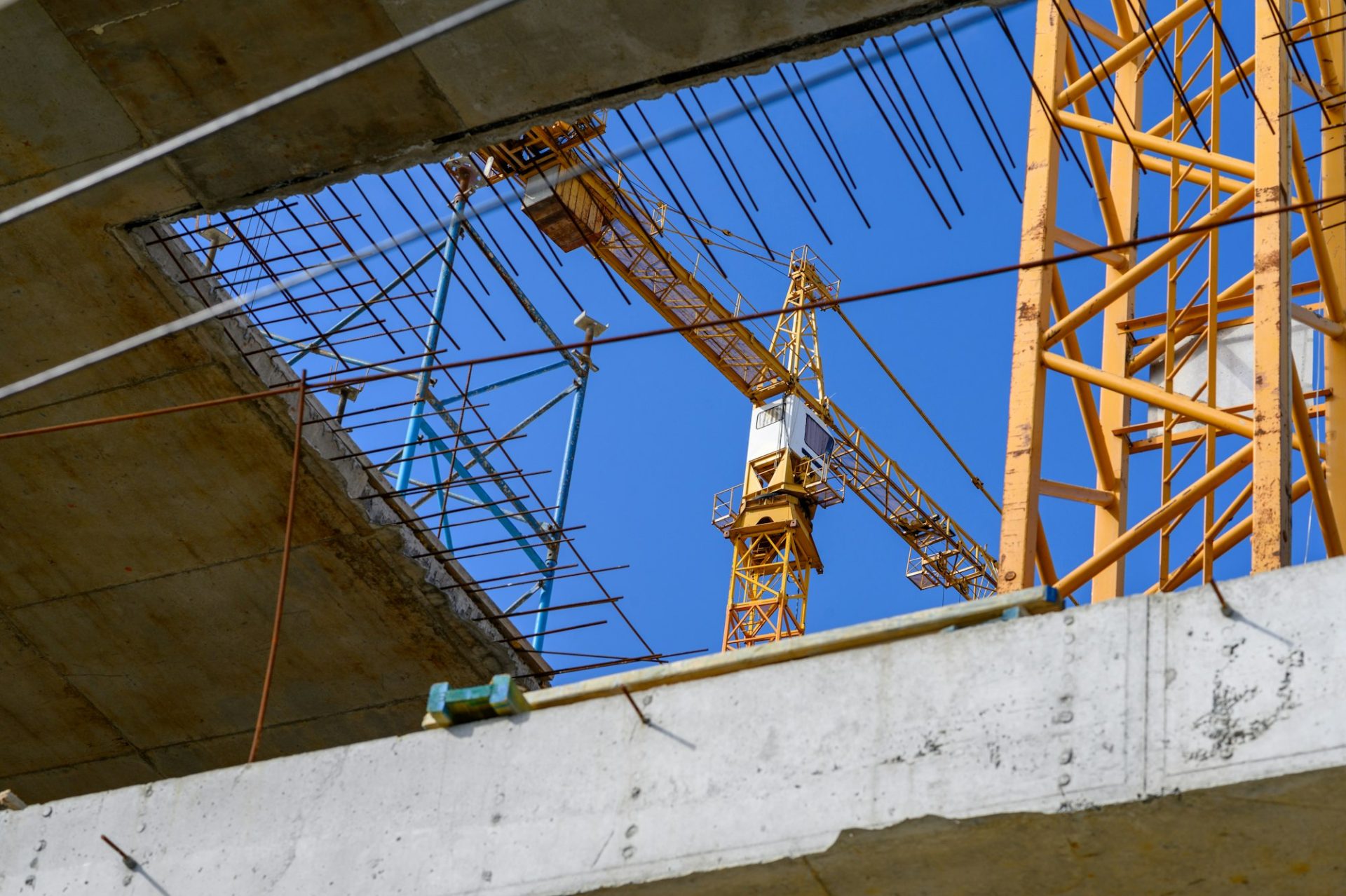 Crane and building construction site against blue sky