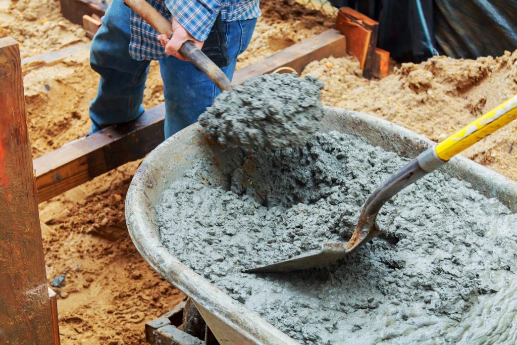 Worker pouring concrete to formwork at construction site